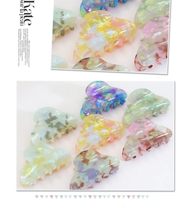 Close-up of pastel marbled heart hair claws in various vibrant macaron colors
