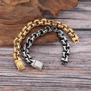Detailansicht der 15 mm Panzerketten-Armbänder in Gold und Silber auf einem Holzhintergrund