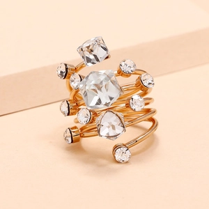 Golden spiral multi-layer crystal ring featuring geometric sparkling gemstones on a warm backdrop