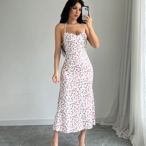 Detailed close-up of white floral midi dress with halter neck and backless cutout design
