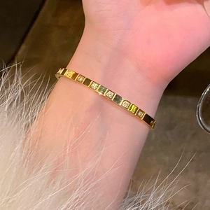 Gold-plated square zircon bangle featuring minimalist rectangular links on female wrist