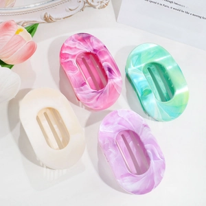 Flat marble patterned hair claws in pink, green, beige and purple on a white background