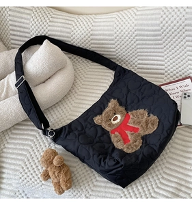 Detail of black quilted heart tote with large teddy bear patch and matching keychain