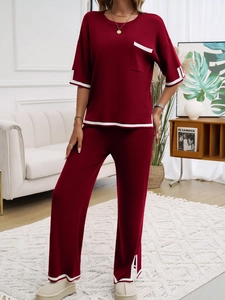 Détail d'un ensemble en maille rouge avec liserés blancs sur le haut et le pantalon