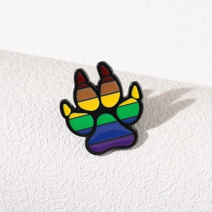 Rainbow enamel animal paw print metal brooch displayed on a white textured background