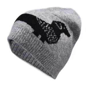 Close-up of grey knit beanie featuring a black dog jacquard pattern and ribbed hem