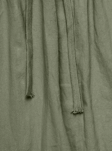 Close-up of sage green linen fabric texture with a matching woven drawstring detail