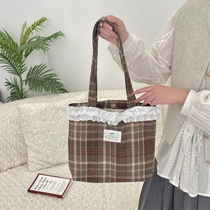 Detail of vintage brown plaid tote bag featuring lace trim and a happy patch detail