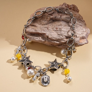 Detail of vintage silver necklace with cross, star charms, pearls and cowboy hat pendant