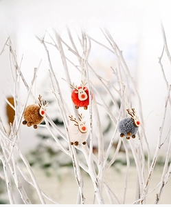 Close-up of four handmade felt reindeer ornaments with wooden faces for Christmas tree decor