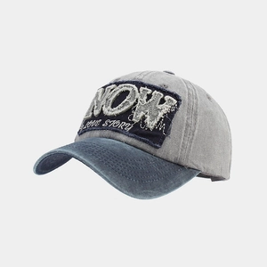 Detail einer Vintage-Baseballkappe mit NOW-Stickerei und gewaschenem Baumwollstoff