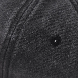 Detail of washed cotton baseball cap with double stitching and embroidered eyelet