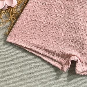 Detail view of pink seersucker fabric texture and high-quality stitching on swimwear