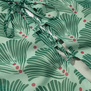 Detail of cross-tie back design on slim fit long dress with green leaf and dot print