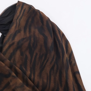 Gros plan détaillé de l'imprimé animal tigre marron et noir sur tissu mousseline translucide
