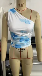 Detail view of white and blue floral one-shoulder top with side ruched elastic fabric