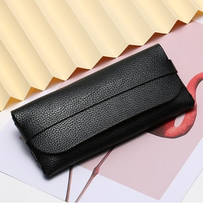 Detail of black litchi grain leather sunglass case with elegant folding flip closure