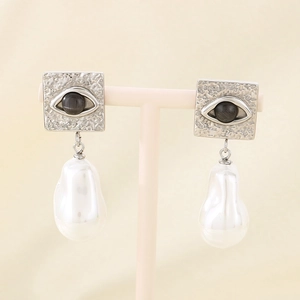 Macro detail of French vintage earrings with square hammered metal and baroque pearls