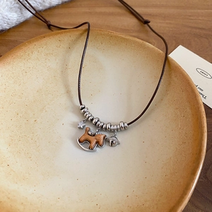 Detail view of a vintage wooden pony necklace with silver stars and a lucky bell