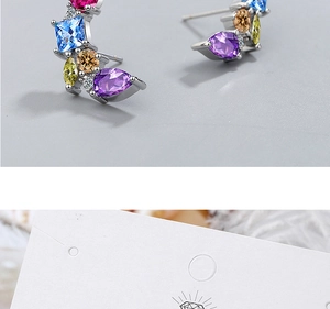Detailed macro view of silver stud earrings featuring vibrant colorful faceted zircons