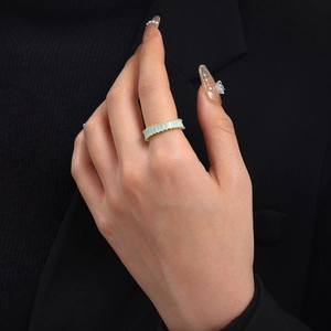 Detail of adjustable gold ring with emerald cut mint green zircon stones on finger