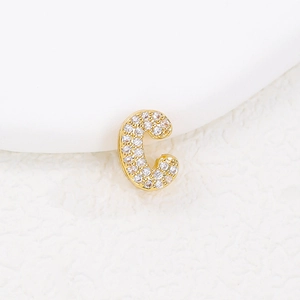 Macro shot of gold letter C pendant with sparkling pave cubic zirconia crystals
