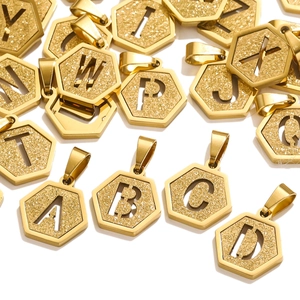 Close-up of hexagonal 18K gold-plated stainless steel alphabet pendants with frosted texture