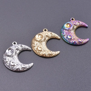 Macro detail showing cratered moon surface texture on colorful stainless steel pendants