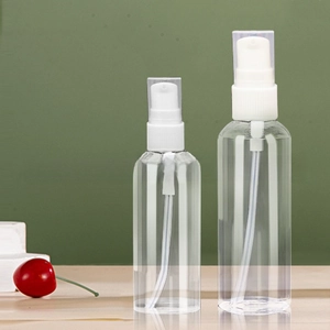 Detail of transparent PET spray bottles with white pump heads and clear dust caps