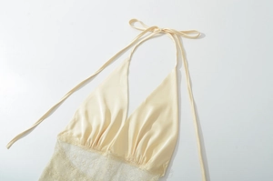 Detail des hellgelben Satinkleids mit zarter Spitze und Halterneck-Design für Damen