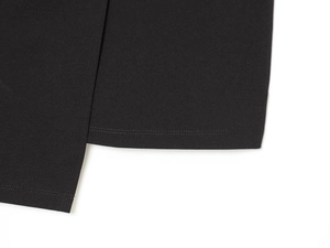 Detaillierte Makroansicht der Doppelnadelnaht am Saum des schwarzen Strickkleides