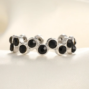 Detailed view of silver tone ring with wave-pattern micro-paved black zircons