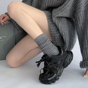 Chunky black multi-material panelled sneakers with grey knit socks and a stylish platform