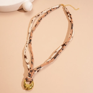 Detail of vintage fabric floral choker with a textured golden metal ring pendant