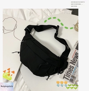 Detail view of black nylon chest bag showing multiple zipper compartments and adjustable strap