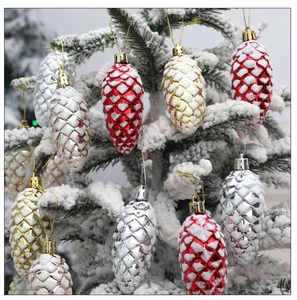 Macro shot of glittery red gold and silver pinecone ornaments on snowy branch