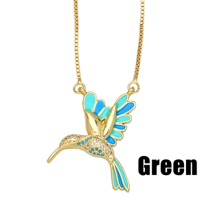 Collier pendentif colibri doré avec émail vert et zircons brillants sur fond blanc