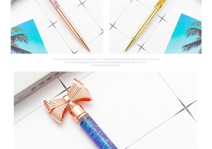 Macro shot of rose gold metal ballpoint pen featuring a glitter liquid barrel and bow top