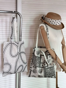 Detail of artistic canvas tote bags with abstract patterns and floral patchwork designs