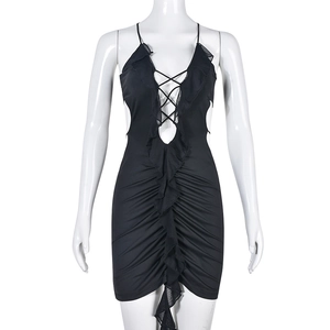 Détail de mini robe noire moulante avec décolleté en V plongeant, fronces et volants
