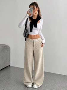 Pantaloni a gamba larga in velluto a coste beige da donna con top corto bianco a maniche lunghe