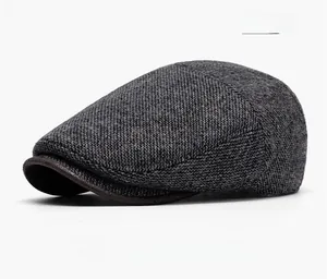 Detail view of dark gray vintage newsboy hat with textured tweed fabric and leather brim edge