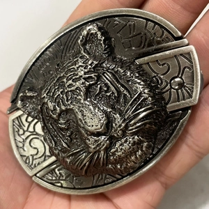 Detailed close-up of vintage silver tiger head buckle with 3D embossed metal carving