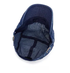 Détail intérieur d'un béret en denim montrant la bande de confort et la boucle en métal