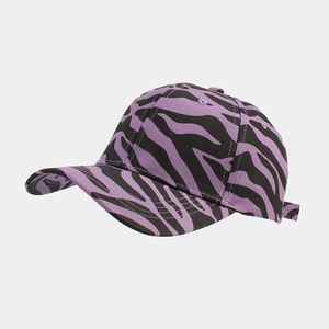 Detail shot of purple and black cow print baseball cap showing fabric texture and seams