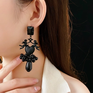Close-up of black baroque angel heart earrings with beaded fringe and drop pendant