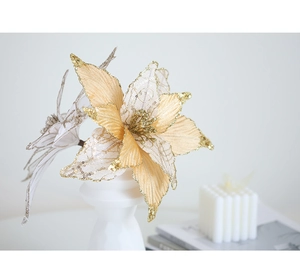Champagne gold artificial Christmas flower on a white stand with home decor accessories