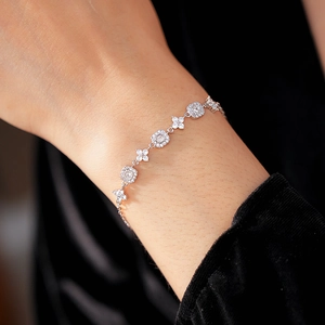 Close-up of a silver-tone floral bracelet featuring square stones and zircon flowers
