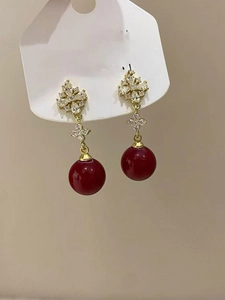 Detail of 18K gold plated flower earrings with red beads and zircon on card