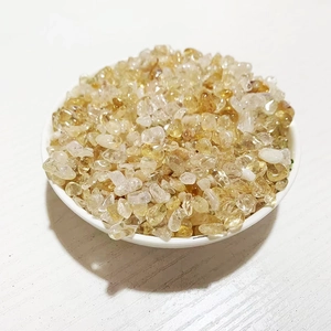 Gros plan de pierres de citrine jaune polies dans un bol en céramique blanche